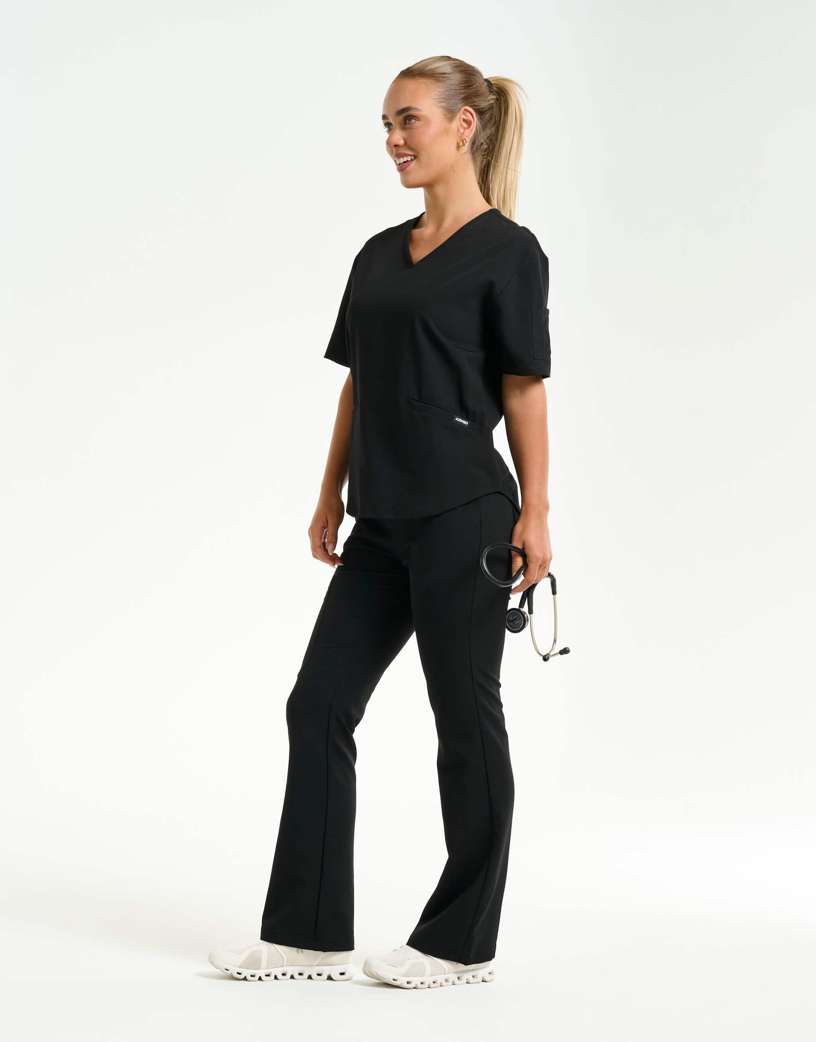 full body with stethascope of black flare scrub pants