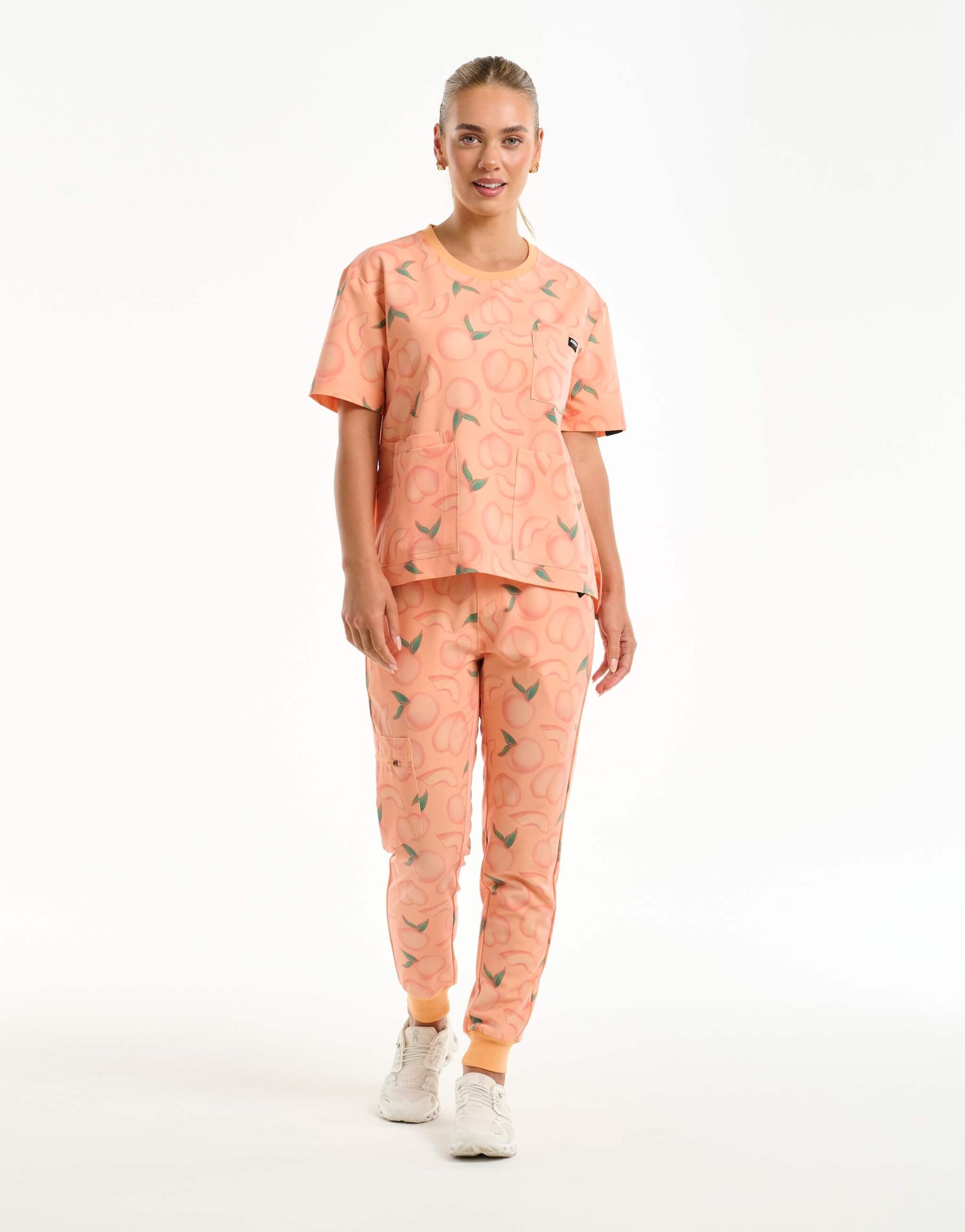 full body view of peach crewneck scrub top