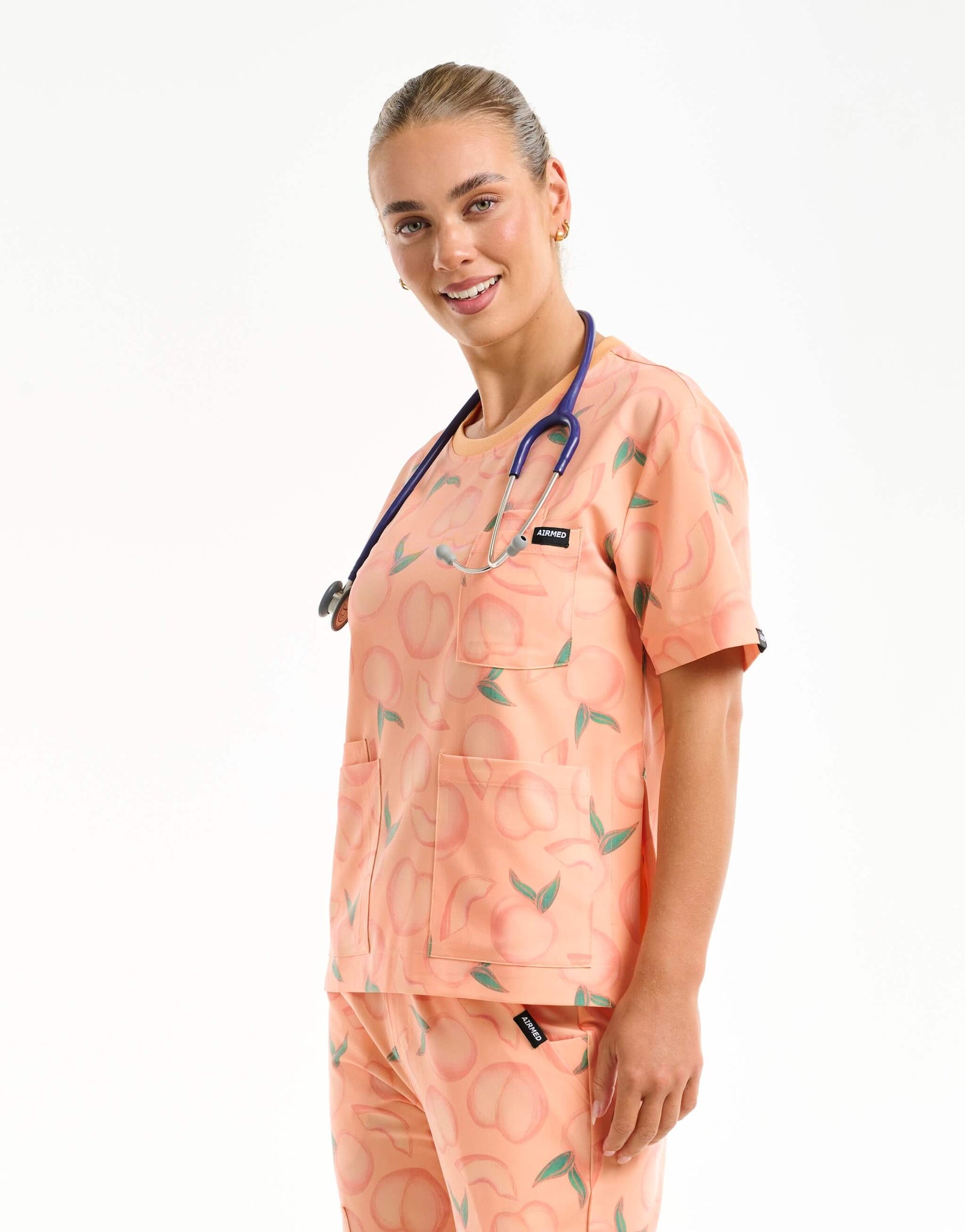 side view of peach crewneck scrub top