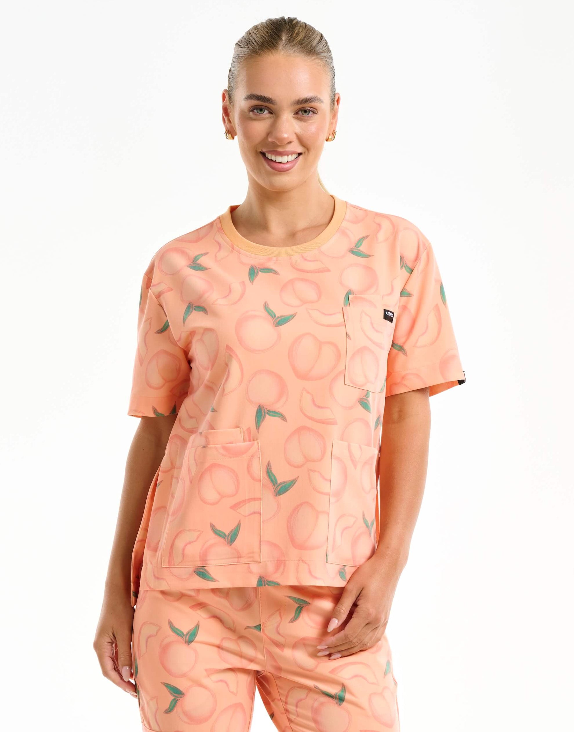 front view of peach crewneck scrub top