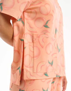 close up of hem detail of peach crewneck scrub top
