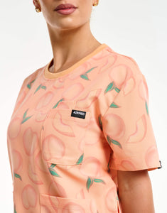 close up of pocket detail of peach crewneck scrub top