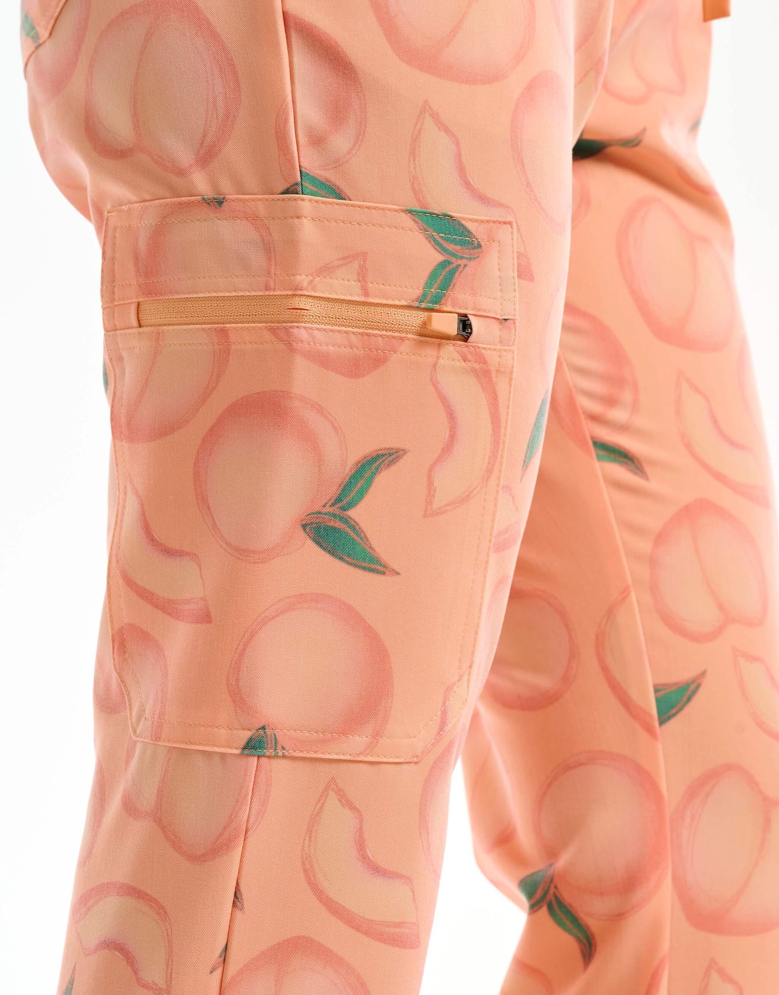 close up of thigh pocket of peach multi-pocket scrub pants