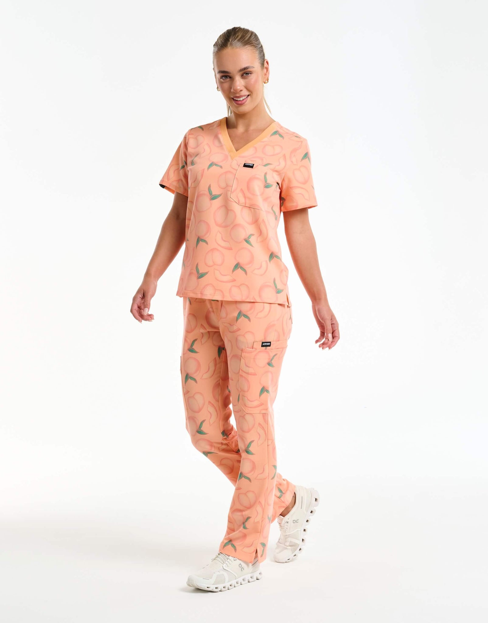 full body view of peach multi-pocket scrub pants