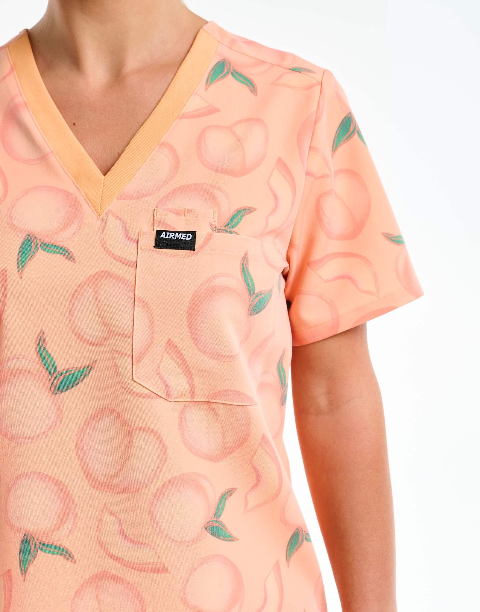 close up of pocket detail of peach one pocket v neck scrub top