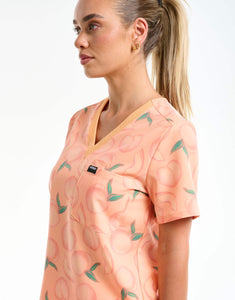 close up of neckline detail of peach one pocket v neck scrub top