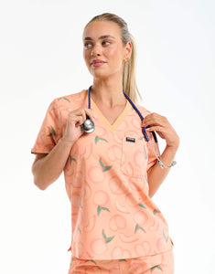 front view with stethoscope of peach one pocket v neck scrub top