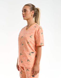 side view of peach v neck scrub top
