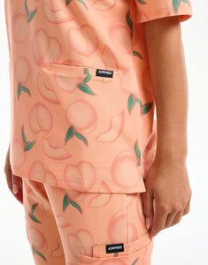 close up of hem detail of peach v neck scrub top