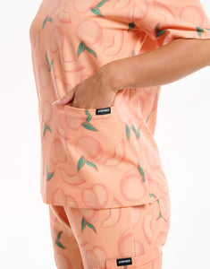close up of pocket detail of peach v neck scrub top