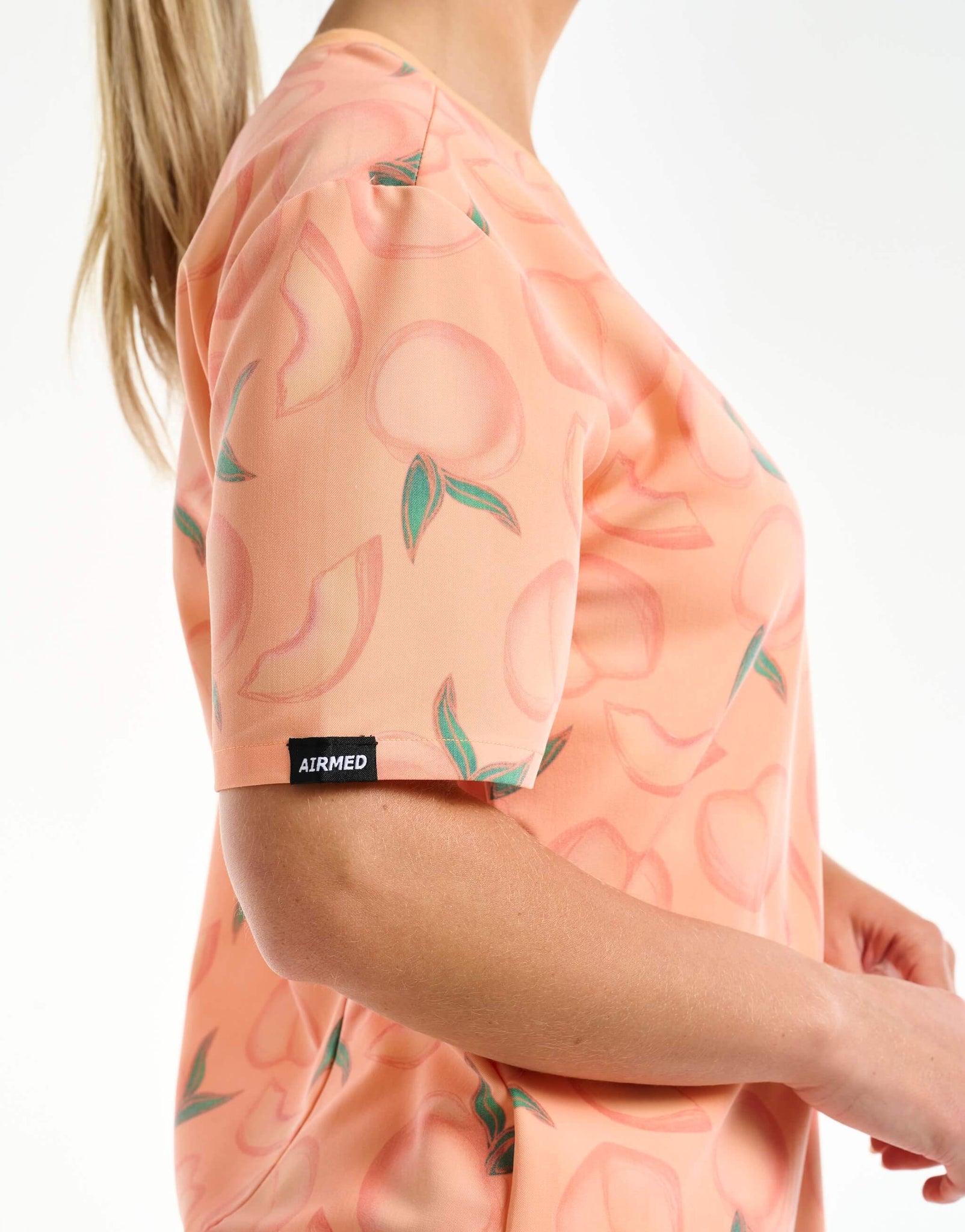 close up of sleeve detail of peach v neck scrub top
