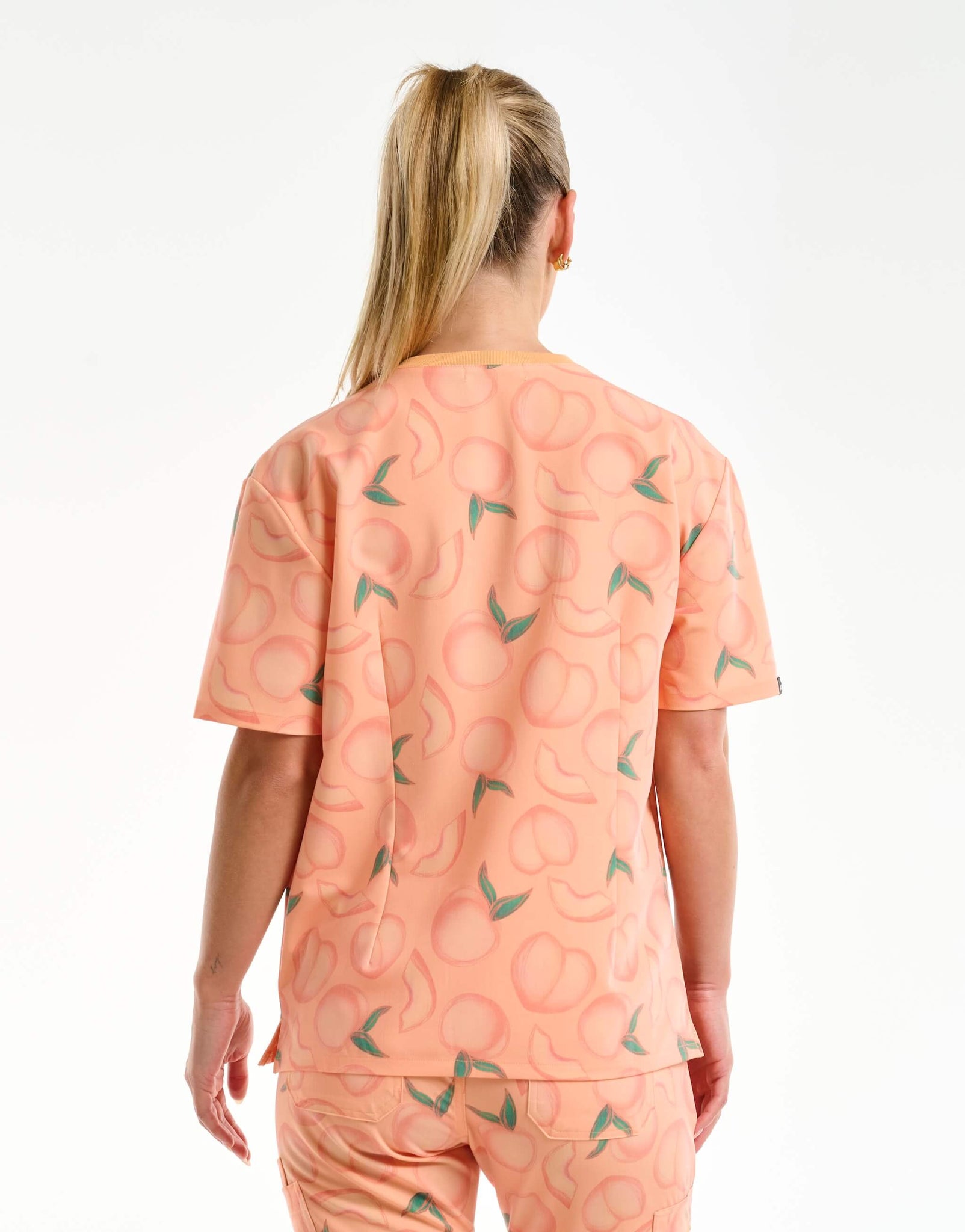 back view of peach v neck scrub top